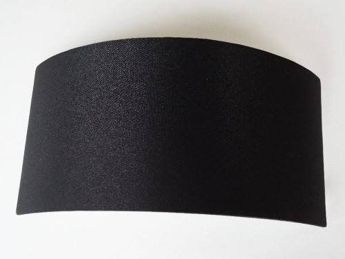 Nowoczesny czarny kinkiet na ścianę z kolekcji HOOP marki PAULO COELHO.  Od wewnątrz srebrzyste podbicie doskonale odbijające światło żarówki.