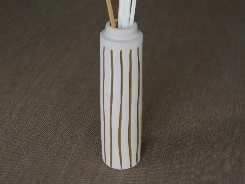 Ceramiczny smukły wazon w kolorze jasno beżowym zdobiony pionowymi nieregularnymi paskami.