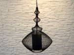 Czarna, ażurowa lampa wisząca OPIUM wykonana z metalowych drutów. Należy do bogatej kolekcji lamp SCHEMA.  Zastosowano w niej dodatkowo czarny, wewnętrzny, cylindryczny abażur.