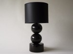 Czarna lampka nocna PERLA z dwoma ceramicznymi, połyskliwymi, glazurowanymi kulami i cylindryczną podstawą. Abażur perkalowy.