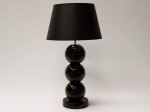 Lampa stołowa z trzema ceramicznymi kulami glazurowanymi na czarny kolor.