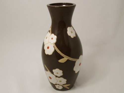 Ciemno brązowy wazon ceramiczny o klasycznym kształcie. Na powierzchni motywy roślinne. Można go napełniać wodą i eksponować świeże cięte kwiaty.