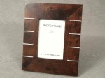 Ramka do zdjęcia wykonana z drewna z dekoracyjnymi metalowymi wstawkami będąca jednym z elementów kolekcji artykułów z drewna. Ramka posiada zaczep pozwalający powiesić ją na ścianie.