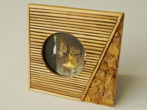 Ramka z okrągłym otworem na zdjęcie. Wykonana z drewna z kamiennymi dekoracyjnymi wstawkami.