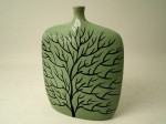 Wyjątkowo płaski wazon ceramiczny z motywem czarnego bezlistnego drzewa na zielonym tle. Motyw jest dwustronny.